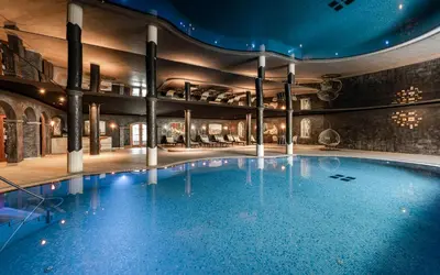 a large swimming pool in a building with a large pool at Hotel Portillo Dolomites 1966' in Selva di Val Gardena
