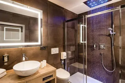 a bathroom with a shower and a sink and a toilet at Grand Hotel Wolkenstein in Selva di Val Gardena