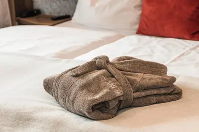 a towel is sitting on top of a bed at Boutique Hotel Planlim in Ortisei