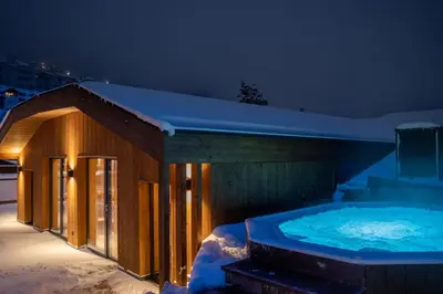 a hot tub on a balcony with mountains in the background at Boutique Hotel Planlim in Ortisei