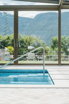 a swimming pool with a view of a mountain at Hotel Girlanerhof in Appiano sulla Strada del Vino