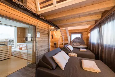 a room with two beds in a log cabin at Hotel La Pineta in Selva di Val Gardena