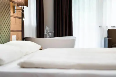 a hotel room with two beds and a sink at Hotel La Pineta in Selva di Val Gardena