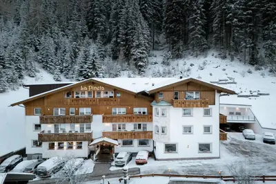 a large building with snow on the ground at Hotel La Pineta in Selva di Val Gardena