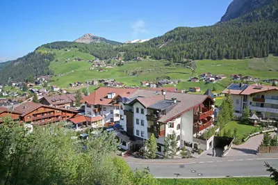 a village in the mountains with houses at Hotel Condor in Selva di Val Gardena