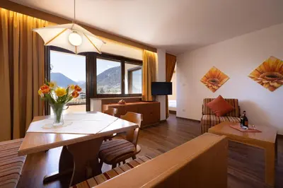 a living room with a table with a vase of flowers at Residence Pollingerhof in Merano