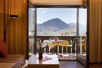 a balcony with a table and a view of a mountain at Residence Pollingerhof in Merano