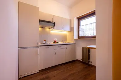 a small kitchen with white cabinets and a window at Residence Pollingerhof in Merano