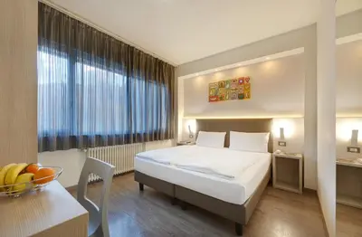 a hotel room with a bed and a table at Hotel Ariston in Bolzano