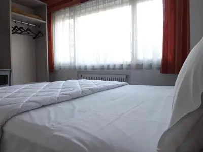 a large white bed in a room with a window at Hotel Ariston in Bolzano