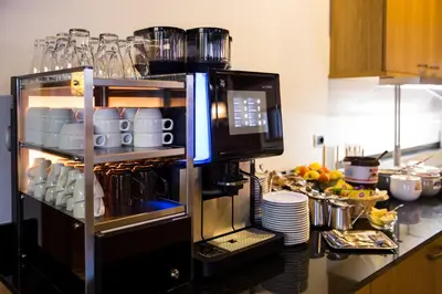 a kitchen with a coffee maker on a counter at Hotel Goldene Rose in Monguelfo