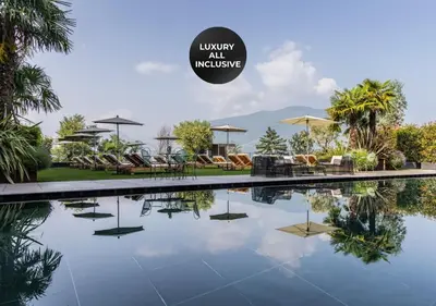a swimming pool with chairs and umbrellas in a resort at SOLEA SÜDTIROL Boutique Hotel in Schenna