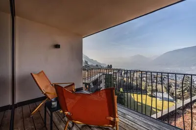 a balcony with two chairs and a view of the ocean at SOLEA SÜDTIROL Boutique Hotel in Schenna