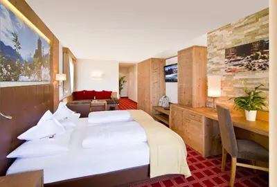 a hotel room with a bed and a desk at Alpentirolis in Tirolo