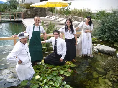 a group of people standing in a pond with water lilies at Alpentirolis in Tirolo