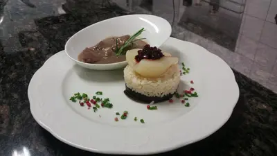 a white plate with a cupcake and a bowl of food at Alpentirolis in Tirolo