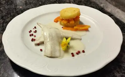 a white plate with a piece of food on it at Alpentirolis in Tirolo
