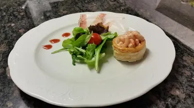 a white plate with a sandwich and salad on it at Alpentirolis in Tirolo