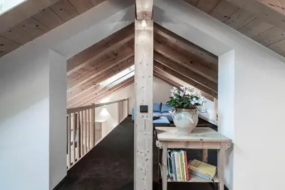 an attic room with a table with a vase on it at Hotel Bad Schörgau in Sarntal