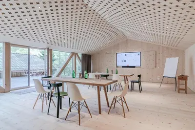 a room with tables and chairs and a projection screen at Hotel Bad Schörgau in Sarntal