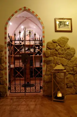 a door to a wine cellar with a stone wall at Hotel Valacia in Pozza di Fassa