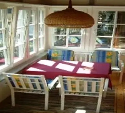 a dining room with a table and chairs and windows at Hubengut Apartments in Lana