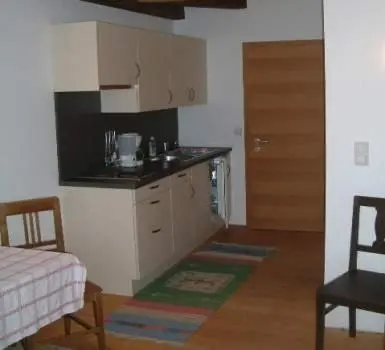 a kitchen with a counter and a table and chairs at Hubengut Apartments in Lana