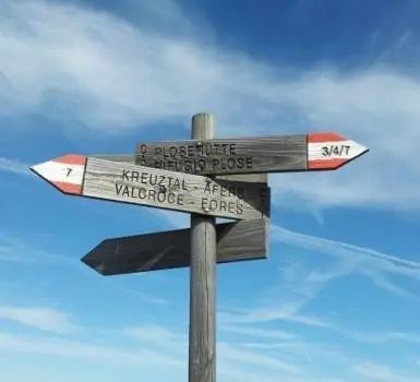 a street sign with two signs on a pole at Hubengut Apartments in Lana