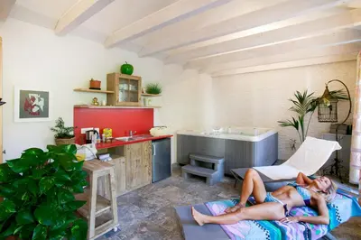 two women laying in a room with a kitchen at Hubengut Apartments in Lana