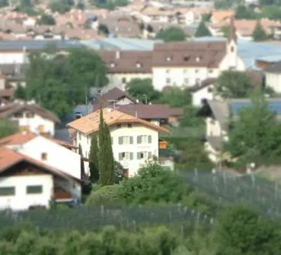 a group of houses in a town with a fence at Hubengut Apartments in Lana