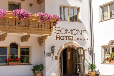 a hotel with flowers on the front of a building at Hotel Somont in Selva di Val Gardena