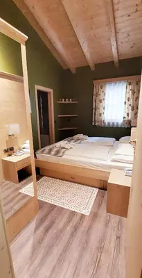 a bedroom with a large bed and a window at Hotel Somont in Selva di Val Gardena