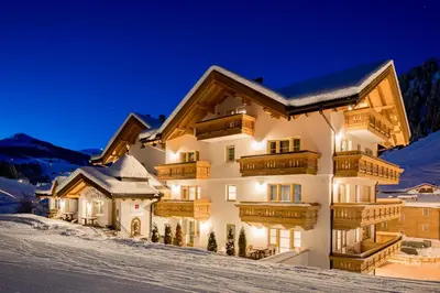 a house in the snow at night at Hotel Somont in Selva di Val Gardena