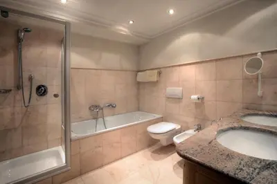 a bathroom with a tub and a toilet and a sink at Residence Dolomieu in San Cassiano