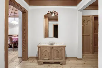 a bathroom with a wooden vanity and a mirror at Residence Dolomieu in San Cassiano