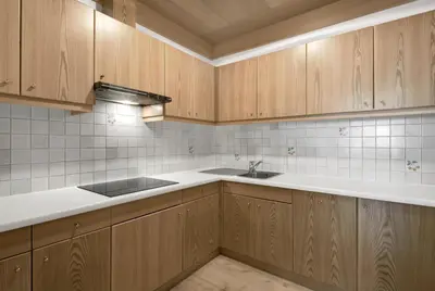 a kitchen with wooden cabinets and a sink at Residence Dolomieu in San Cassiano