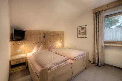 a bedroom with a large bed and a window at Residence Dolomieu in San Cassiano