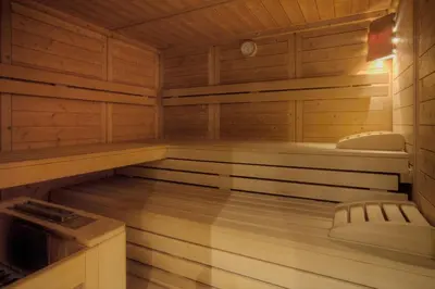 a sauna with wooden walls and a wooden floor at Hotel Ciasa Ai Pini in San Cassiano