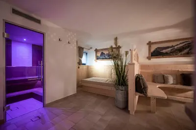 a bathroom with a bed and a shower with purple lighting at Residence Cesa Sassela in Ortisei