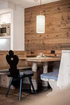 a dining room with a wooden table and chairs at Residence Cesa Sassela in Ortisei