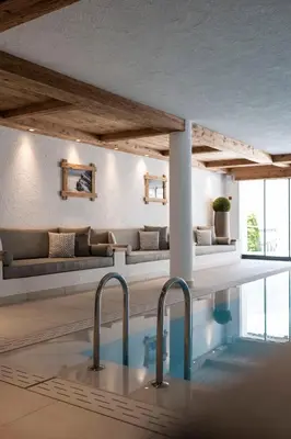 a pool in a room with a couch and a table at Residence Cesa Sassela in Ortisei