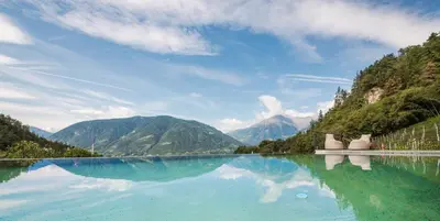 a large body of water with mountains in the background at Hotel Kiendl in Schenna