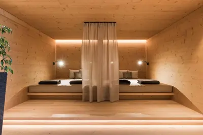 two beds in a room with wooden walls at Hotel Kiendl in Schenna
