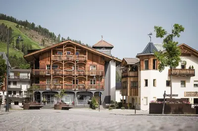 a large wooden building in the middle of a street at Christophorus Mountain Residence in San Vigilio Di Marebbe