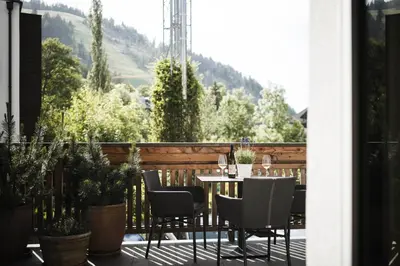 a table and chairs on a balcony with a view at Christophorus Mountain Residence in San Vigilio Di Marebbe