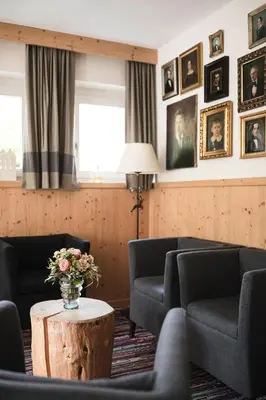 a waiting room with chairs and a table with a vase of flowers at Christophorus Mountain Residence in San Vigilio Di Marebbe