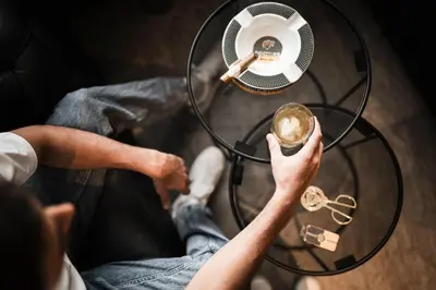 a man holding a table with a fan and keys at Hotel Plan de Gralba - das Berghotel in Selva di Val Gardena