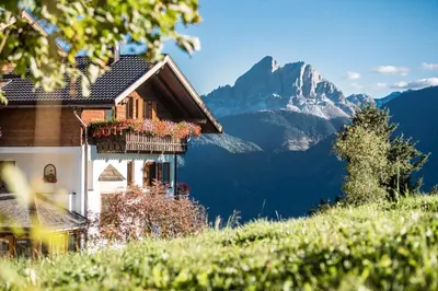 a house with a balcony with mountains in the background at Herol - my mountain retreat in Luson