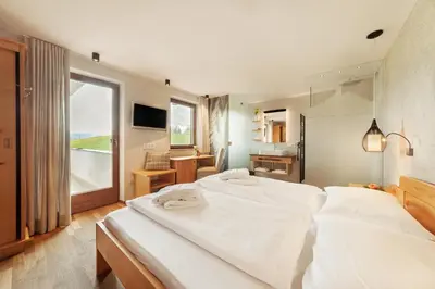 a large white bed in a bedroom with a window at Herol - my mountain retreat in Luson