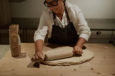 a woman kneading a piece of dough on a table at Herol - my mountain retreat in Luson